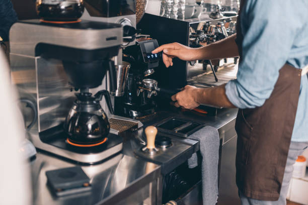 istock Man in front of the coffee machine pressing the button on it 1152014263