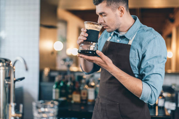 istock Concentrated barista smelling coffee with closed eyes 1152014334