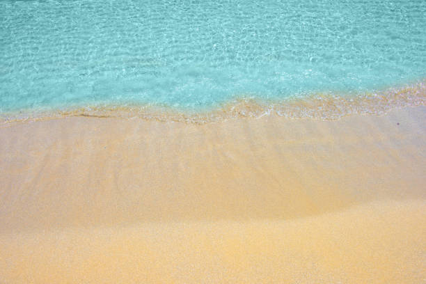 Soft wave of turquoise sea water on the sandy beach.