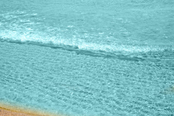 Soft wave of turquoise sea water on the sandy beach.