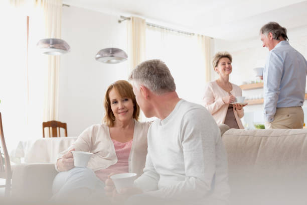 istock Mature couples talking in living room at home 1152021734