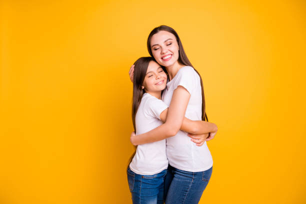 istock Close up side profile photo beautiful her she diversity different age eyes closed hold hands arms each other waited meeting wear casual white t-shirts jeans denim isolated yellow bright background 1152021841