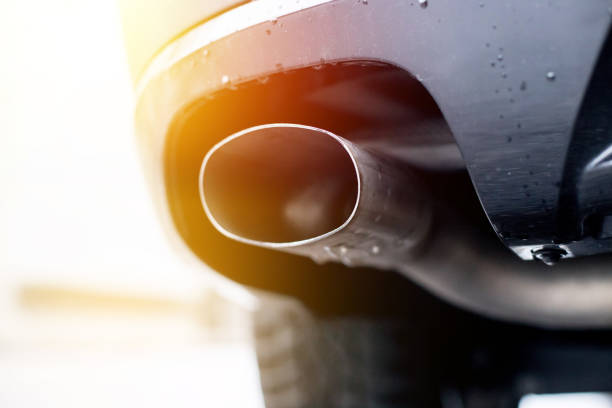 Powerful car with exhaust pipe, pollution and fine dust Close up of an exhaust pipe of a car, environmental pollution. Sunlight. exhaust pipe photos stock pictures, royalty-free photos & images