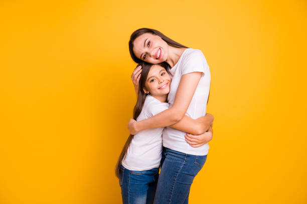 istock Close up side profile photo beautiful her she diversity lady different age hold hands arms each other waited meeting buddies wear casual white t-shirts jeans denim isolated yellow bright background 1152022526