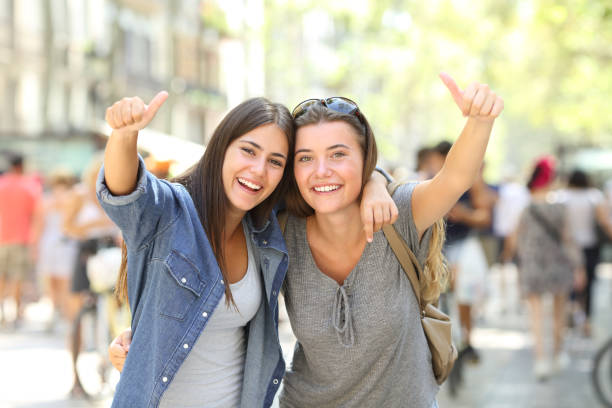 istock Two happy friends gesturing thumbs up together 1152023733