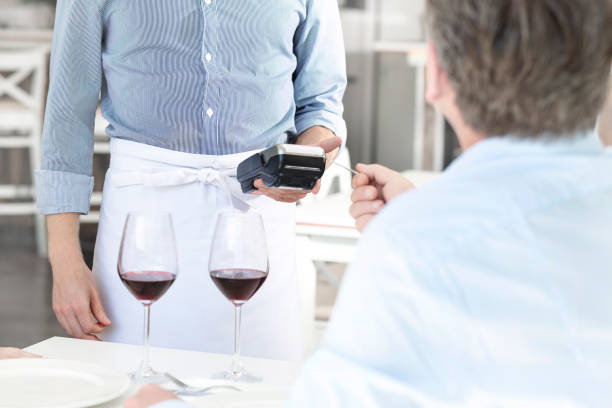 istock Mature customer paying through credit card at restaurant 1152025382