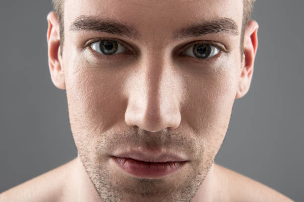 istock Handsome young man with stubble standing against blue-gray background 1152026523
