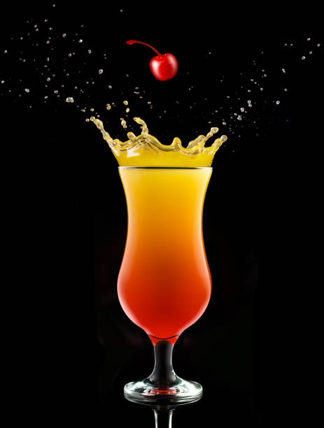 tequila sunrise or sex on the beach splashing cocktail cherry falling into a splashing tequila sunrise isolated on black tequila sunrise stock pictures, royalty-free photos & images