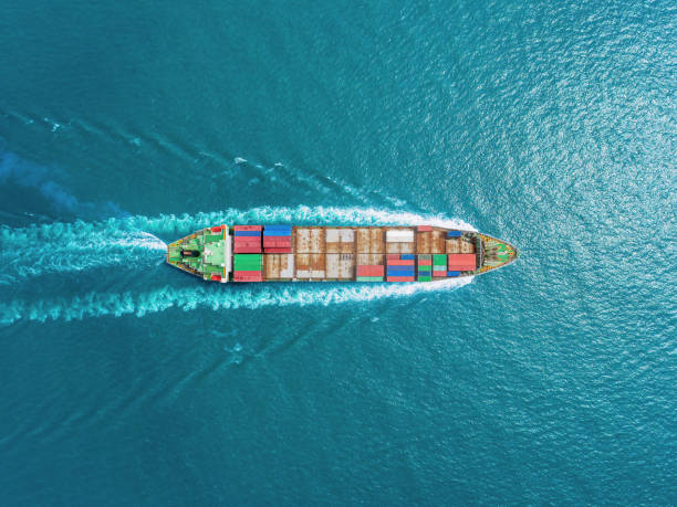 istock Aerial top view container ship full speed with beautiful wave pattern on the blue sea for logistics, import export, shipping or transportation. 1152029177