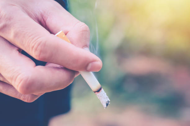 istock man hand holding a cigarette for smoking ,a cigarette is burning, they create more chemicals. These nicotine, tar, and carbon monoxide, formaldehyde, ammonia, hydrogen cyanide, arsenic and DDT 1152035953