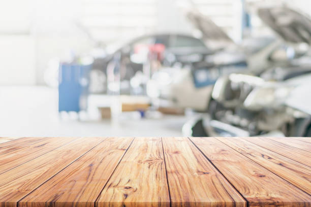 Wood table top on blurred Car Repair Services Center Blurred use us automobile maintenance technician repair background used us montage display or products design stock photo