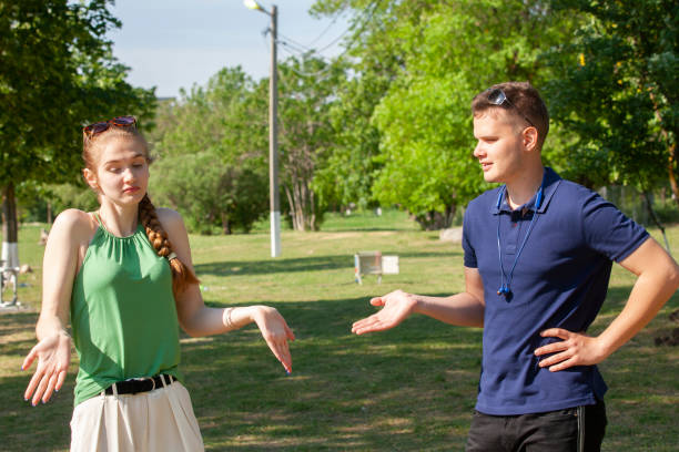 istock Young couple arguing while sitting on bench in park. Problems in relationship 1152039833