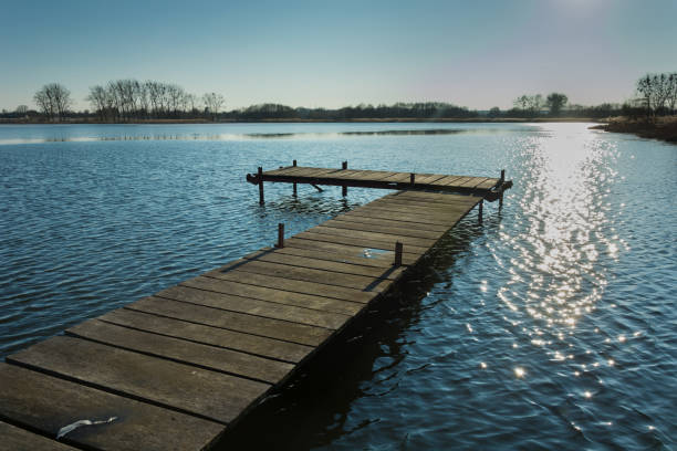 istock Jetty on the lake. Reflecting sunlight in water 1152039961