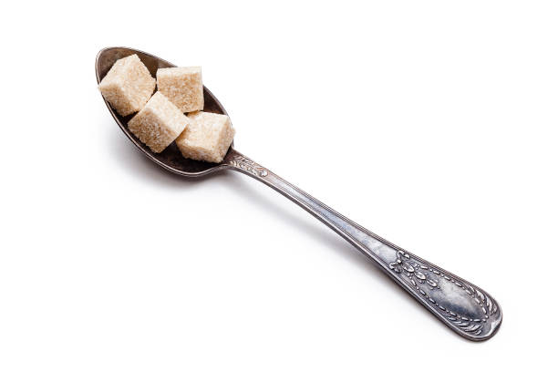 cubos de azúcar marrón orgánico de caña de azúcar aislada en blanco - syrup brown sugar sugar spoon fotografías e imágenes de stock