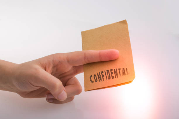 istock Hand holding a brown color paper with text confidental 1152040668