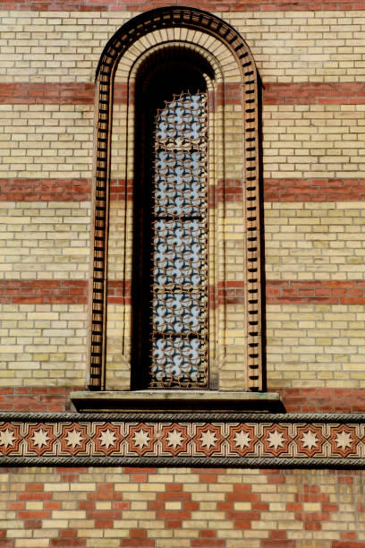 Great Synagogue in Budapest. Exterior facade carved brick arch and fine brick work detail in yellow and red. Budapest landmark and tourist attraction. Jewish Budapest. Moorish style window.