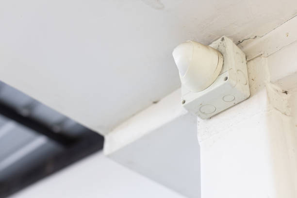 istock closeup of closed circuit television camera or CCTV and box control on white concrete ceiling. 1152042083