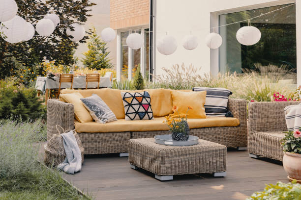 istock Flowers on rattan table near couch with patterned cushions on the terrace with lanterns. Real photo 1152048278