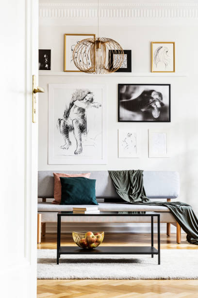 istock Table in front of grey settee with blanket in bright living room interior with posters. Real photo 1152048622