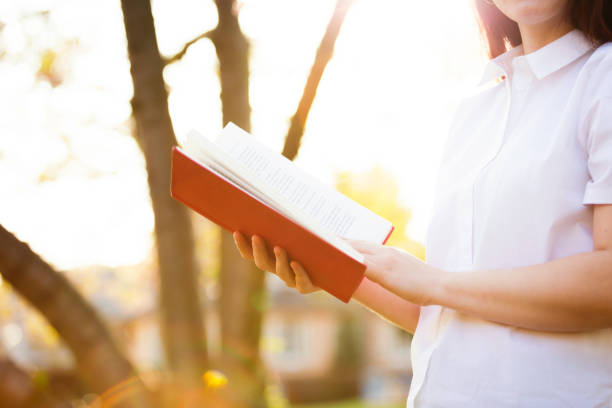 istock holding a red book over sunny background 1152050374