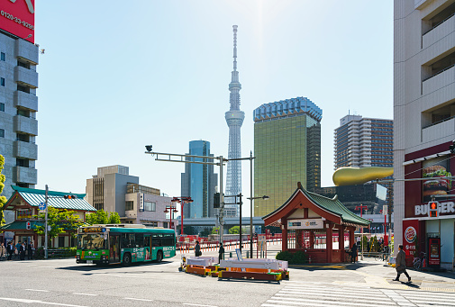 Tokyo, Japan - May 8, 2019: Tokyo skyline with Tokyo Sky Tree tower and traditionally stylized subway station entrance.