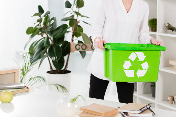 istock cropped view of woman holding recycling box while standing in office, environmental saving concept 1152056441