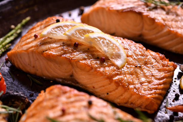 istock Grilled salmon fish with various vegetables on pan on the flaming grill 1152059113