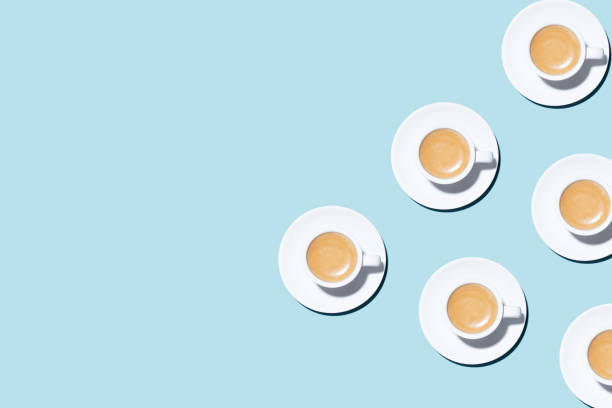 Pattern made of cup of cappuccino on blue background.