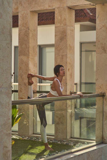 istock Merry young female is stretching legs on balcony 1152072727