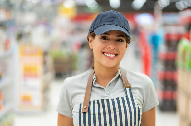 istock Pretty cheerful young administrator of a grocery store facing camera smiling wearing uniform 1152073321