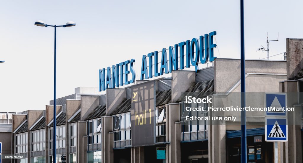 view of the facade of Nantes Atlantique International Airport Nantes, France - August 7, 2018: view of the facade of Nantes Atlantique International Airport where travelers are walking on a summer day Nantes Stock Photo