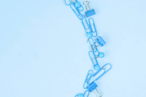 Blue background with small stationery clips and clips in the form of a semicircle.
