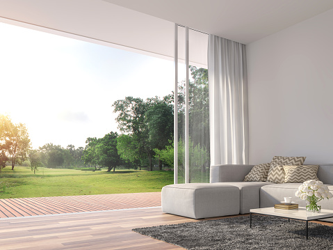 Modern living room 3d render.The Rooms have wooden floors ,decorate with white fabric  sofa,There are large open sliding doors, Overlooks wooden terrace and big garden.