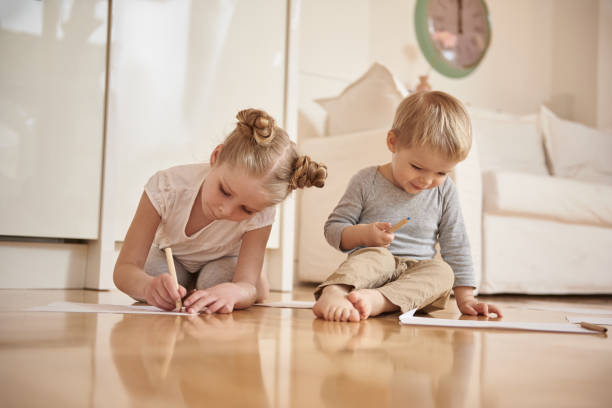 istock Adorable kids drawing with colored pencils at home 1152078896