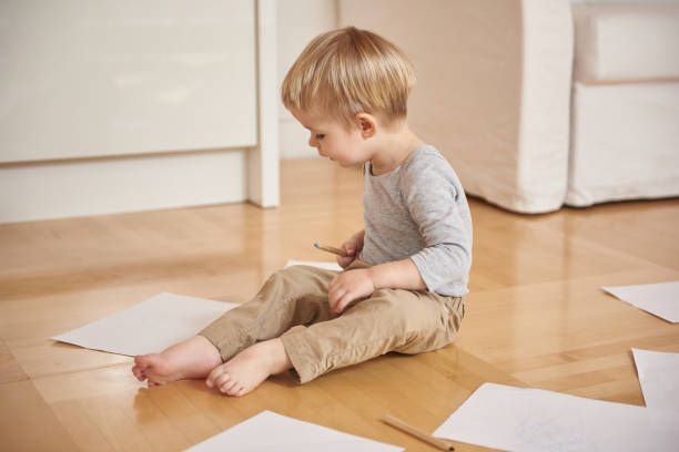istock Adorable little boy drawing with colored pencil at home 1152078898