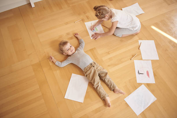 istock Cute kids with colored pencils drawing and resting at home 1152078940