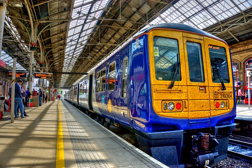 Preston, United Kingdom - May 14, 2019: Preston railway station In north west England with train at platform and passengers some motion blurred on adjacent platforms