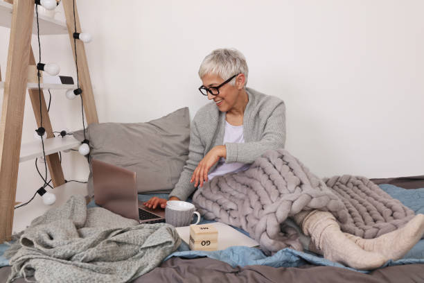 istock Cozy and comfy, Woman covered with soft woolen blanket, relaxing at home,drinking cacao, using laptop. 1152079608