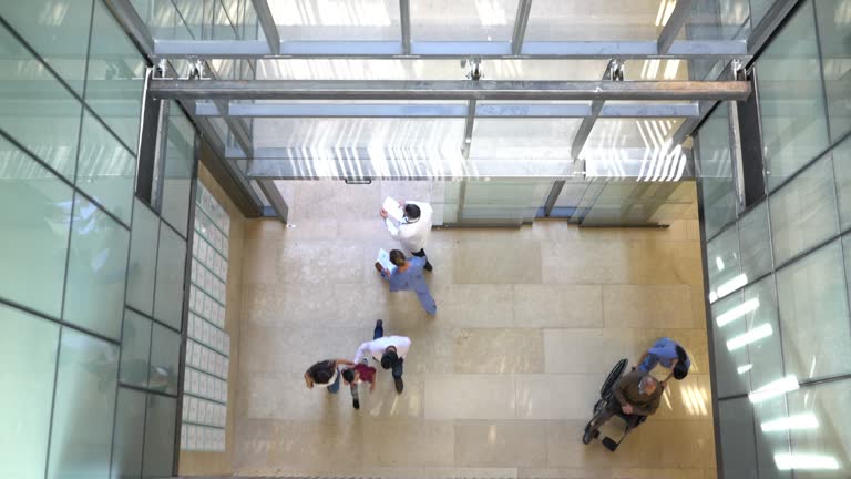 High angle view of people and healthcare professionals walking in and out of the hospital