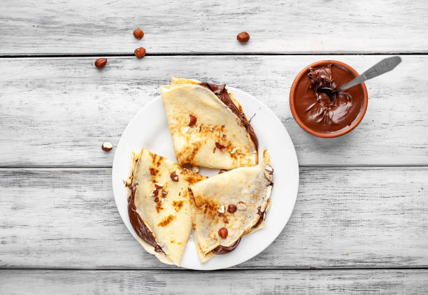 istock Pancakes with chocolate spread and hazelnuts,  on a white plate on a wood background 1152081882