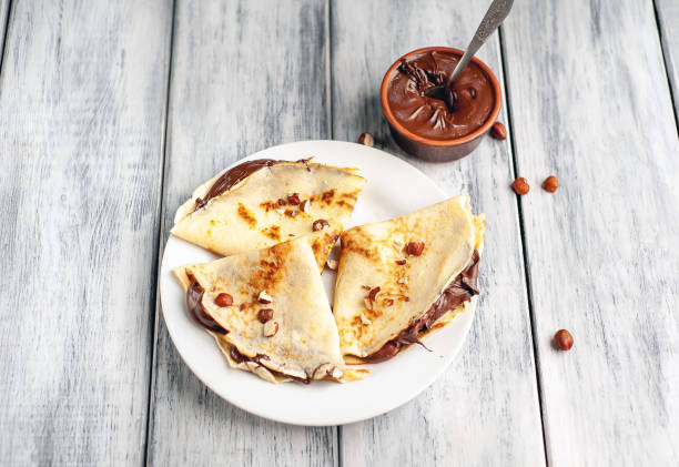 istock Pancakes with chocolate spread and hazelnuts,  on a white plate on a wood background 1152081886