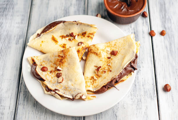 istock Pancakes with chocolate spread and hazelnuts,  on a white plate on a wood background 1152081893