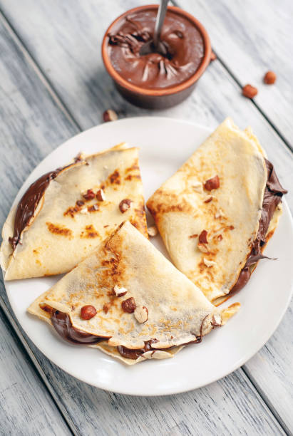 istock Pancakes with chocolate spread and hazelnuts,  on a white plate on a wood background 1152081897
