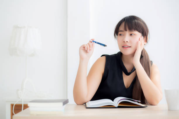 istock Beautiful asian woman writer smiling thinking idea and writing on notebook or diary with happy on desk office, lifestyle of asia girl is success, female planning working, education and business concept. 1152082111