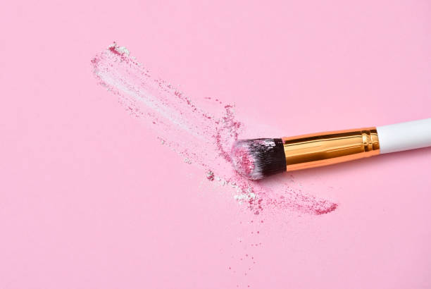 istock Makeup Brush on pink Background with Colorful Pigment Powder. Top view 1152085155