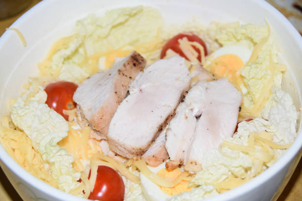 Fresh and healthy chicken salad made with shredded chicken. crisp lettuce, tomatoes and cucumbers.