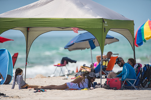 Hollywood, FL, USA - May 27, 2019: Image of a family under a tent on the beach Memorial Day Weekend
