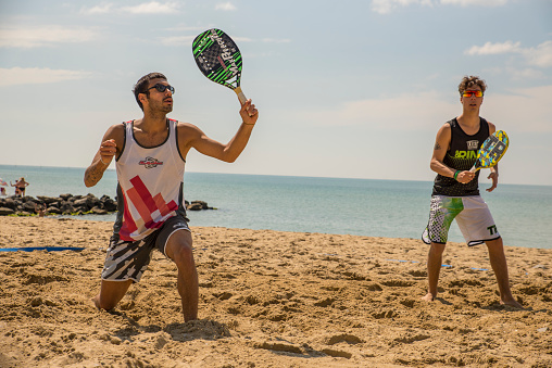 Sveti Vlas, Bulgarial - May 25, 2019: Young mans playing beach tennis on  beach