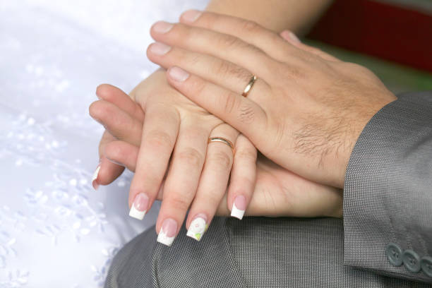 istock bride and groom show their hands wearing wedding rings 1152096728