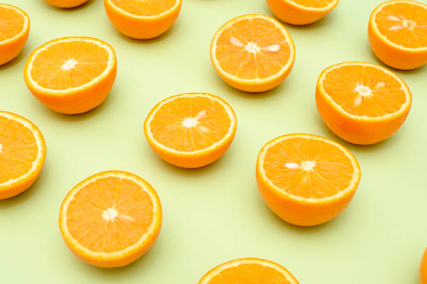 istock Orange juicy oranges split in half on green 1152107857